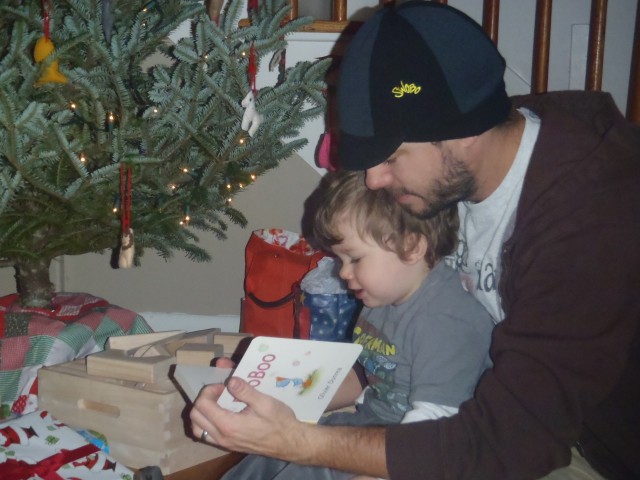 Jeff reading Abe one of his gift books on Christmas morning